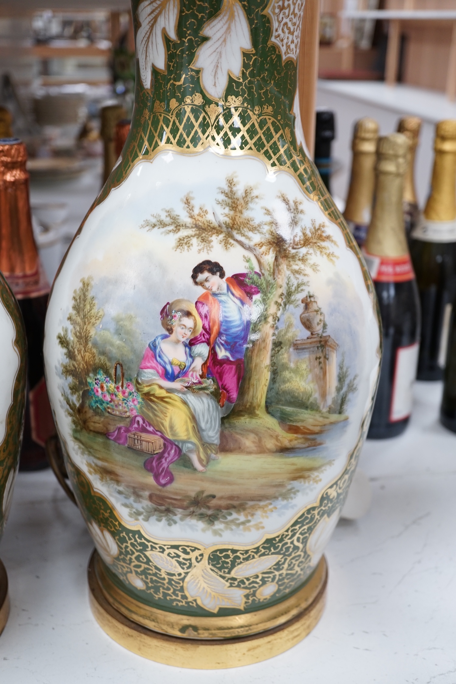 A large pair of Continental porcelain vases converted to lamps, painted with figures before landscapes, 51cm high excluding the fitting. Condition - fair to good. Untested.